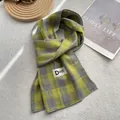 Detalle de bufanda de algodón a cuadros amarillos y grises con etiqueta de marca en alfombra - 180*60cm / Amarillo Limón