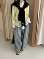 Chic layered look with yellow knit sweater, white shirt, black shawl, and denim jeans - Black