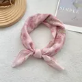Detail of pink paisley silk scarf tied in a bow on a minimalist wood and leather tray - 58*58cm / Paisley Pink