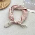 Flat lay of square silk scarf with red rose pattern and geometric borders on plush background - 58*58cm / Leaf Apricot