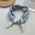 Close-up of lightweight blue and white floral silk scarf with elegant paisley patterns - White Paisley