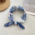 Macro detail of bohemian geometric silk scarf with blue and pink patterns on wooden tray - 58*58cm / Blue