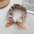 Close-up of bohemian silk scarf with orange and brown geometric patterns and knotted detail - 58*58cm / Orange