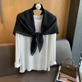 Détail d'un t-shirt blanc à manches longues assorti d'une écharpe noire à pois fins - Noir