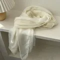 Primer plano detallado de bufanda plisada blanco crema con costuras finas y etiqueta - 120x190cm / Blanco Roto