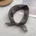 Dettaglio di un piccolo foulard con motivo a rombi su morbido sfondo di peluche bianco - Stile Quadrato Piccolo / Grigio Bluastro