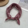 Detail of dusty pink paisley print cotton scarf tied elegantly on a plush background - Large Square / Red