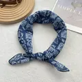 Detail of blue and white floral silk scarf showing premium texture and knot styling - Geometric