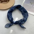 Close-up of blue and white floral silk scarf with thin texture used as a stylish hair tie - Blue Flower