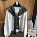 Chic classic striped knit shawl draped over a Northwestern University grey sweatshirt - Black