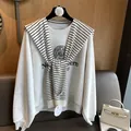 Detail view of gray Northwestern University sweatshirt with striped knit shawl accent - White