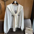 Detail eines weißen Häkel-Schals kombiniert mit einem grauen Northwestern Sweatshirt - Creme