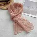 Detail eines hellrosa Spitzen-Halstuchs mit Blumenstickerei und Wellenrändern - Rosa