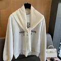 Détail d'un sweat-shirt gris avec un châle en maille ajourée blanche et nœud élégant - Crème