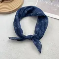 Elegant navy blue floral silk scarf tied in a bow on a minimalist grey background - Tree Branch