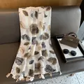 Detail des Schals mit Tiermustern, Blattmotiven und beigen Quasten am Saum - 180*70cm / Khaki