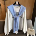 Detail of light blue knit shawl with hollow pattern paired with grey college sweatshirt - Blue