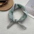 Détail d'un foulard en soie à imprimé floral sur un fond texturé blanc épuré - Gardénia Vert / 70x70cm