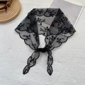 Detail of black floral lace triangle headscarf with scalloped edges on white textured cloth - 88x26cm / Black