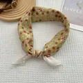 Gros plan d'un foulard en soie à fleurs jaune avec motif de baies utilisé comme ruban - Cerise Jaune / 70x70cm
