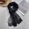 Close-up of black floral lace scarf with embroidery and scalloped edges on white fabric - 140*19cm / Black