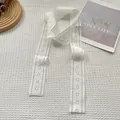 Detail of white lace scarf showing intricate floral patterns and geometric eyelets - White Gardenia Lace