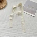 Dettaglio di sciarpa in pizzo bianco crema con ricamo floreale e stile vintage raffinato - Fiore Cavo