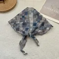 Gros plan d'un foulard géométrique bleu avec bords ondulés sur une texture gaufrée - Bleu à Carreaux