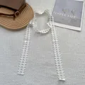 Dettaglio della sciarpa in pizzo bianco con trama geometrica e finitura traforata - Piccolo cubo