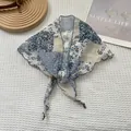 Detail van een chiffon sjaal met paisley-print en elegante ruisranden op houten standaard - Blauw