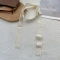 Dettaglio della sciarpa in pizzo bianco con ricamo floreale e bordi traforati decorativi - Fiore Vuoto