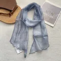 Détail d'un foulard en soie bleu clair avec motifs mandala blancs sur fond en tissu gaufré - 18x165cm / Bleu Azur