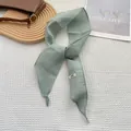 Detalle de una bufanda fina de lino verde claro con textura de tela hecha a mano - Verde