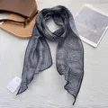 Détail d'un foulard en soie gris à motif paisley avec étiquette de produit authentique - 18x165cm / Noir
