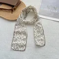 Detail of vintage floral cotton linen scarf with brown wavy edges on a white tray - Floral Beige