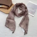 Détail d'un foulard en soie marron à motif cachemire avec bords ondulés sur tissu gaufré - 18x165cm / café