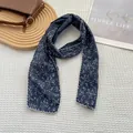 Detail of navy floral cotton scarf with white scalloped edges on a textured background - Navy Blue Floral