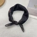 Detalle de un pañuelo de seda vintage con estampado paisley sobre tela de nido de abeja - Gris