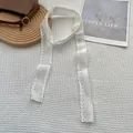 Close-up of white French lace ribbon with floral embroidery on white textured fabric - Wild Daisy / 75x4cm