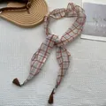 Detail of plaid silk scarf with tassels on textured white fabric and wood decor - Blue and Brown Grid (4)