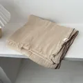 Detalle de bufanda de lino beige con textura arrugada, flecos y un borde marrón - 180*70cm / Blanco Roto