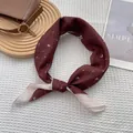 Detail of burgundy heart-pattern silk scarf knotted on a stylish wooden tray - Heart Jujube Red