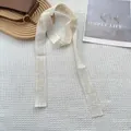 Detail van gebroken wit kanten lint met borduursel op witte wafelstof textuur - Beige Bloemenborduurstijl (3)