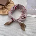 Close-up of pink silk scarf with floral patterns on a textured waffle background - Blurred Flower Bean Paste Pink