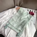 Écharpe légère en coton vert clair à fleurs avec pompons sur une chemise blanche - Style Floral à Gland / Vert clair