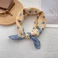Detailed view of yellow and blue silk scarf with paisley pattern and floral dots - 70x70cm / Yellow