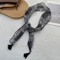 Dettaglio di una sciarpa stretta con stampa floreale e nappe nere su fondo bianco - Floreale Patchwork Nero Grigio Bianco (20)