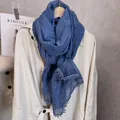 Detalle de chal azul denim en algodón y lino con encaje calado sobre abrigo blanco - 180x90cm / Azul Denim