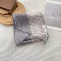 Detail of color-block narrow silk scarf with floral pattern and brand hangtag on magazine - Gray