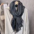 Detail of dark charcoal cotton linen scarf featuring delicate lace trim on a hanger - Black and Gray